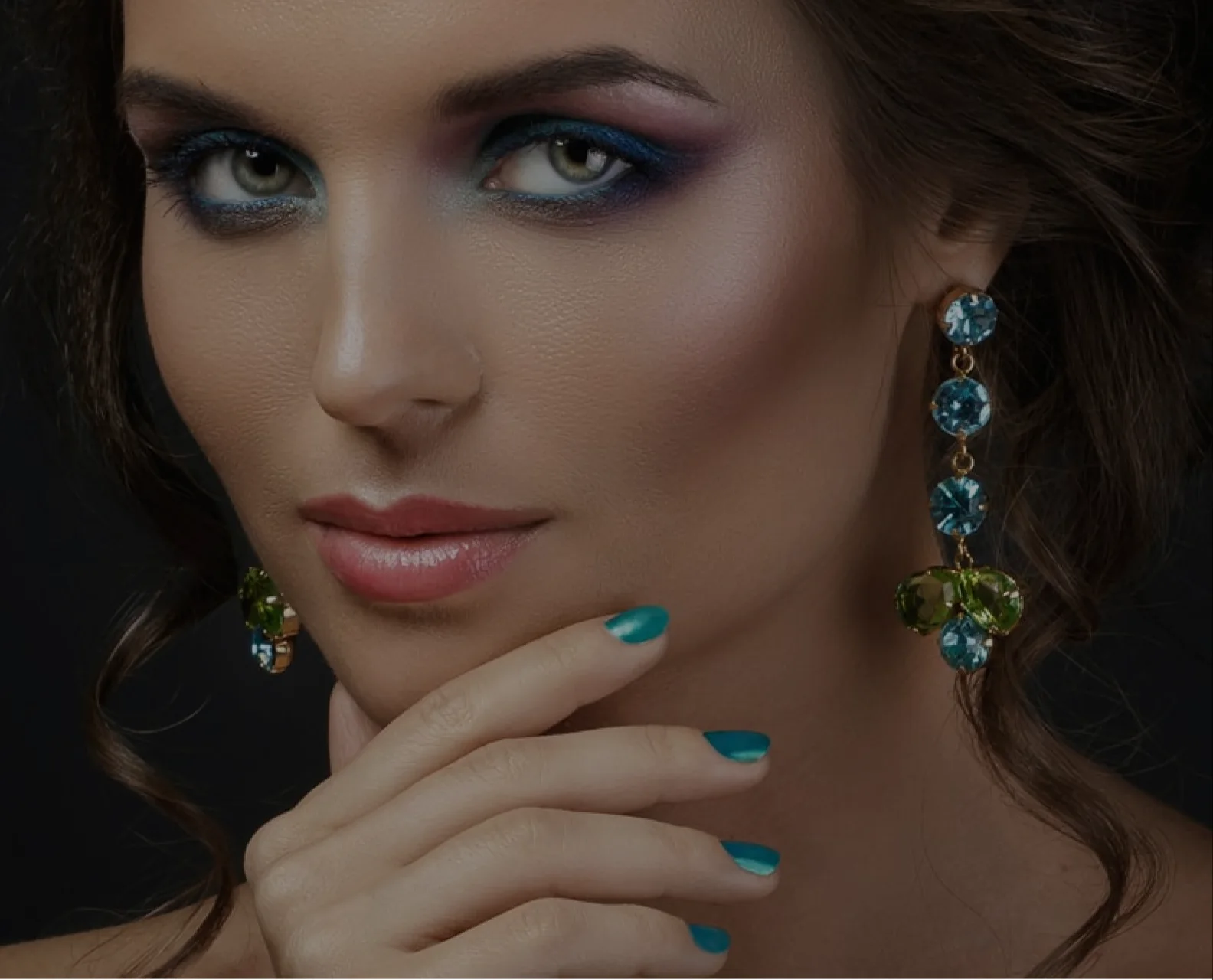 Model wearing teal and green gemstone drop earrings