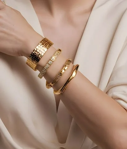 Stacked gold bangles on a wrist